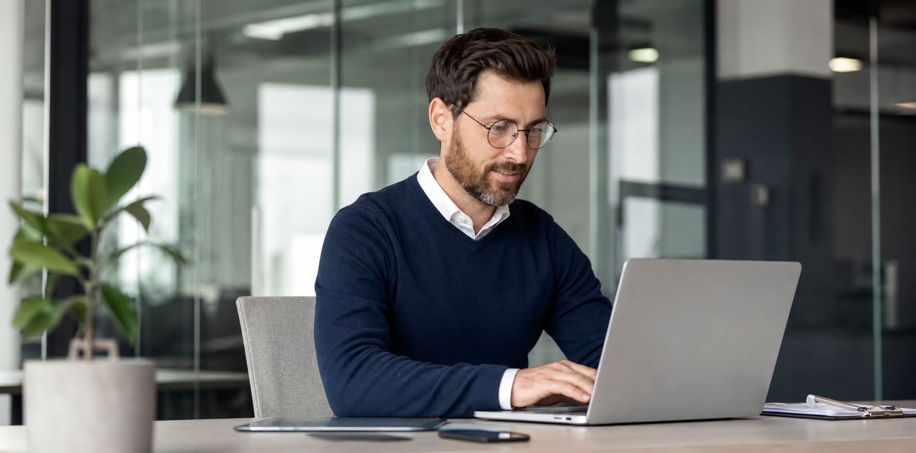 Finance specialist working on a laptop in a modern corporate office